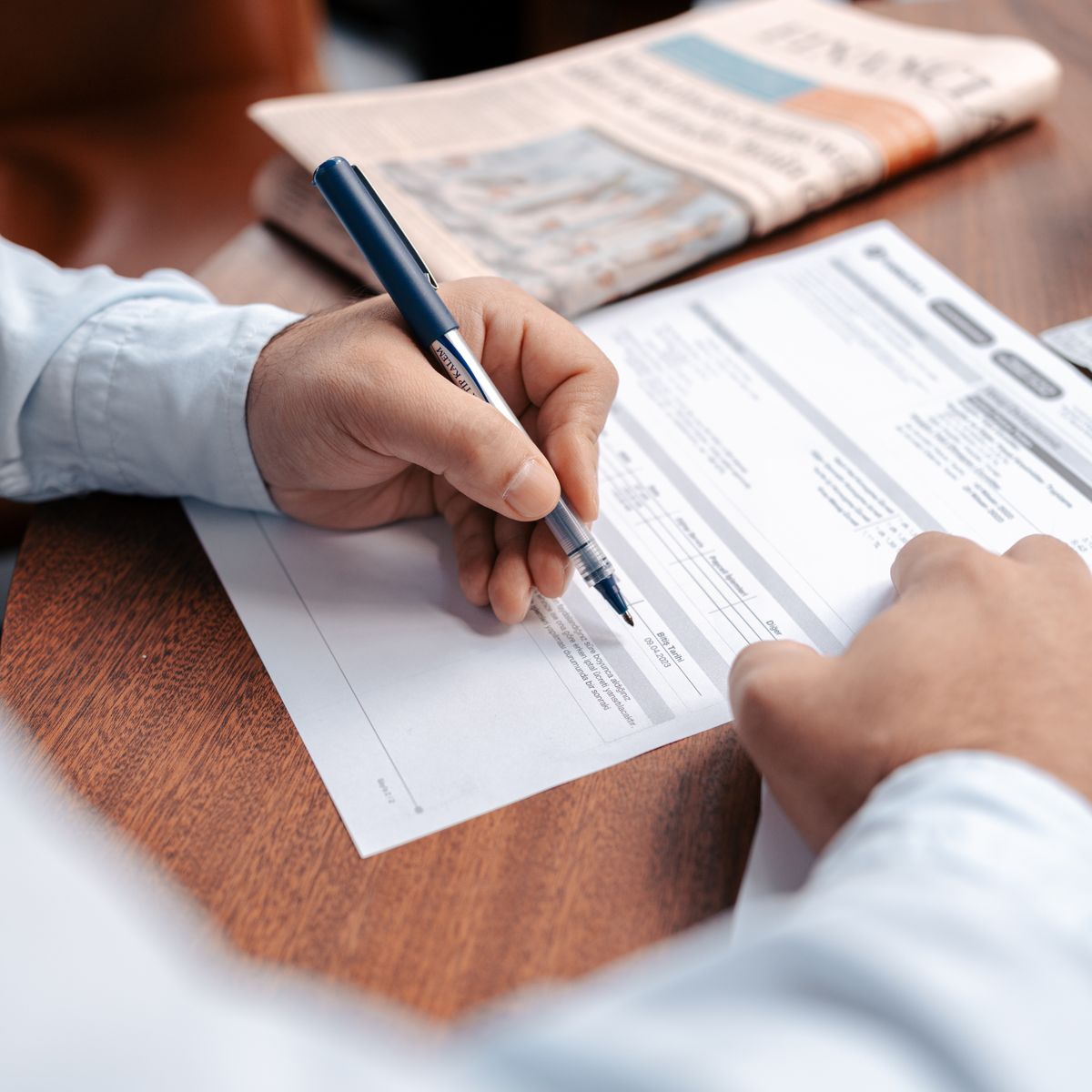Personne calculant son budget de travaux avec une calculatrice et des documents financiers