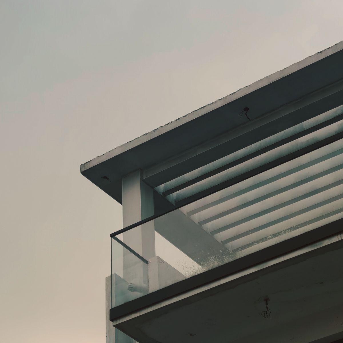 Coin de bâtiment moderne fermé avec balustrade en verre au design épuré et vitré