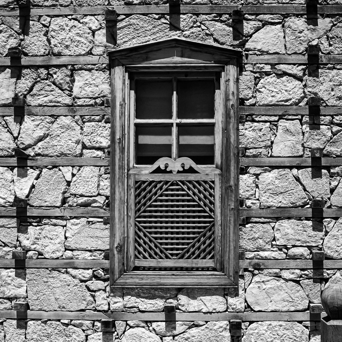 Ancienne fenêtre encastrée dans un mur de pierre rustique en noir et blanc