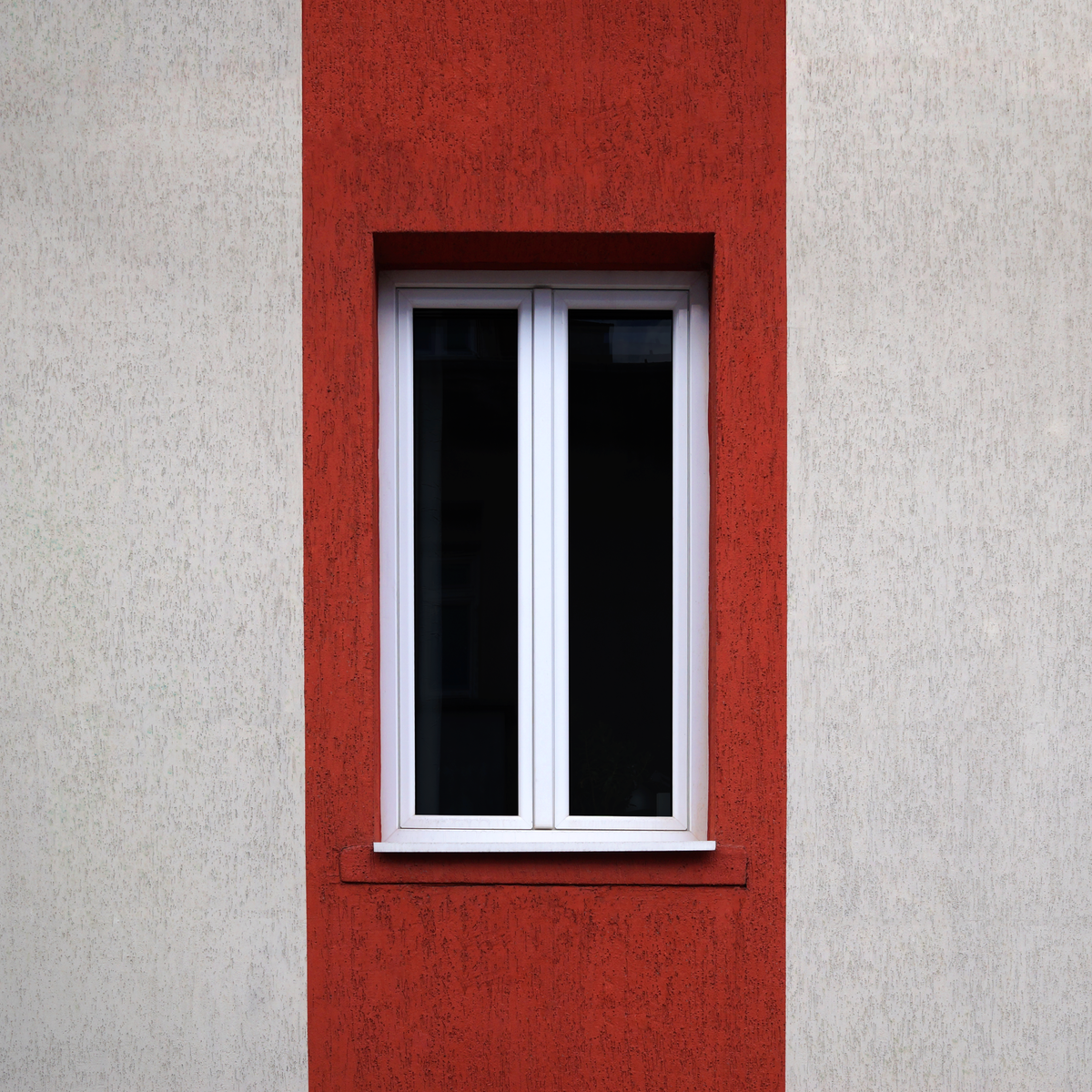 Fenêtre moderne au design rouge et blanc illustrant le choix du matériau