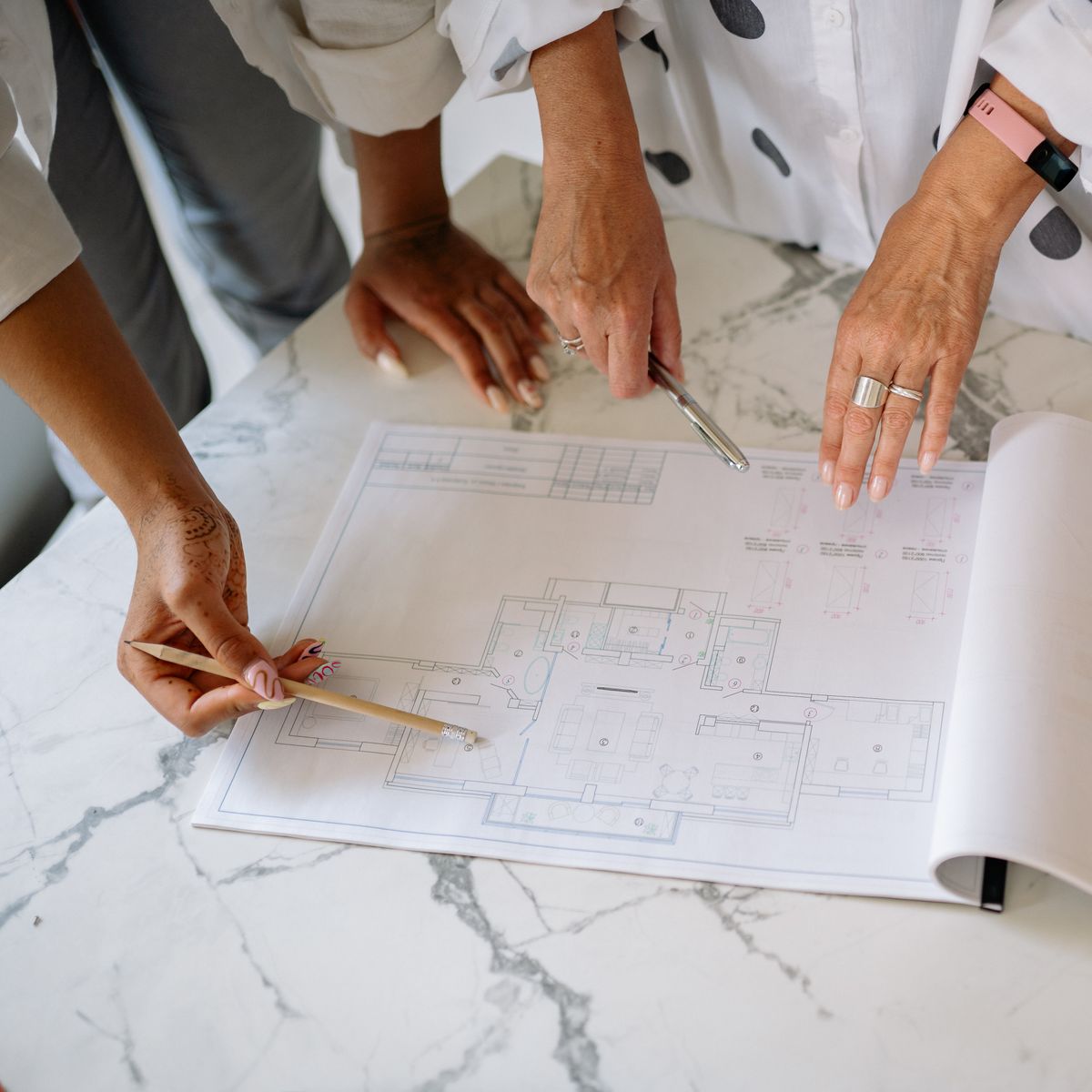 Deux personnes examinant ensemble des plans architecturaux posés sur une table