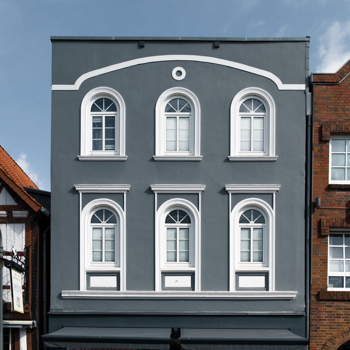 Façade de maison avec fenêtres et volets, illustrant la pose de volets roulants à Besançon