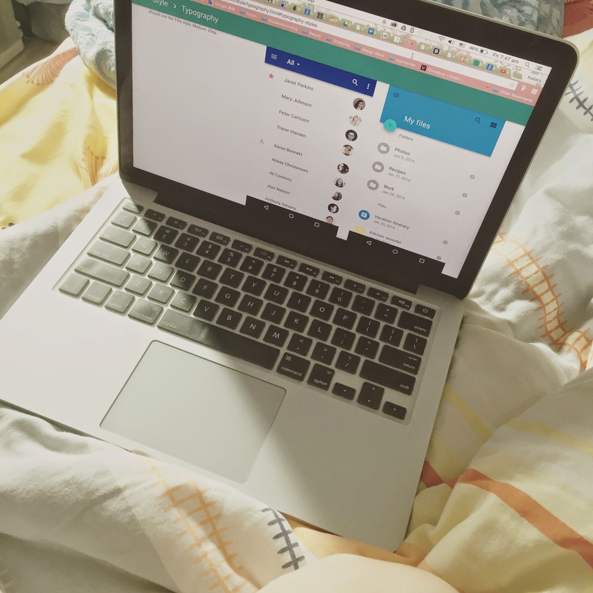 Ordinateur portable ouvert affichant une interface en ligne, vue de dessus sur un lit